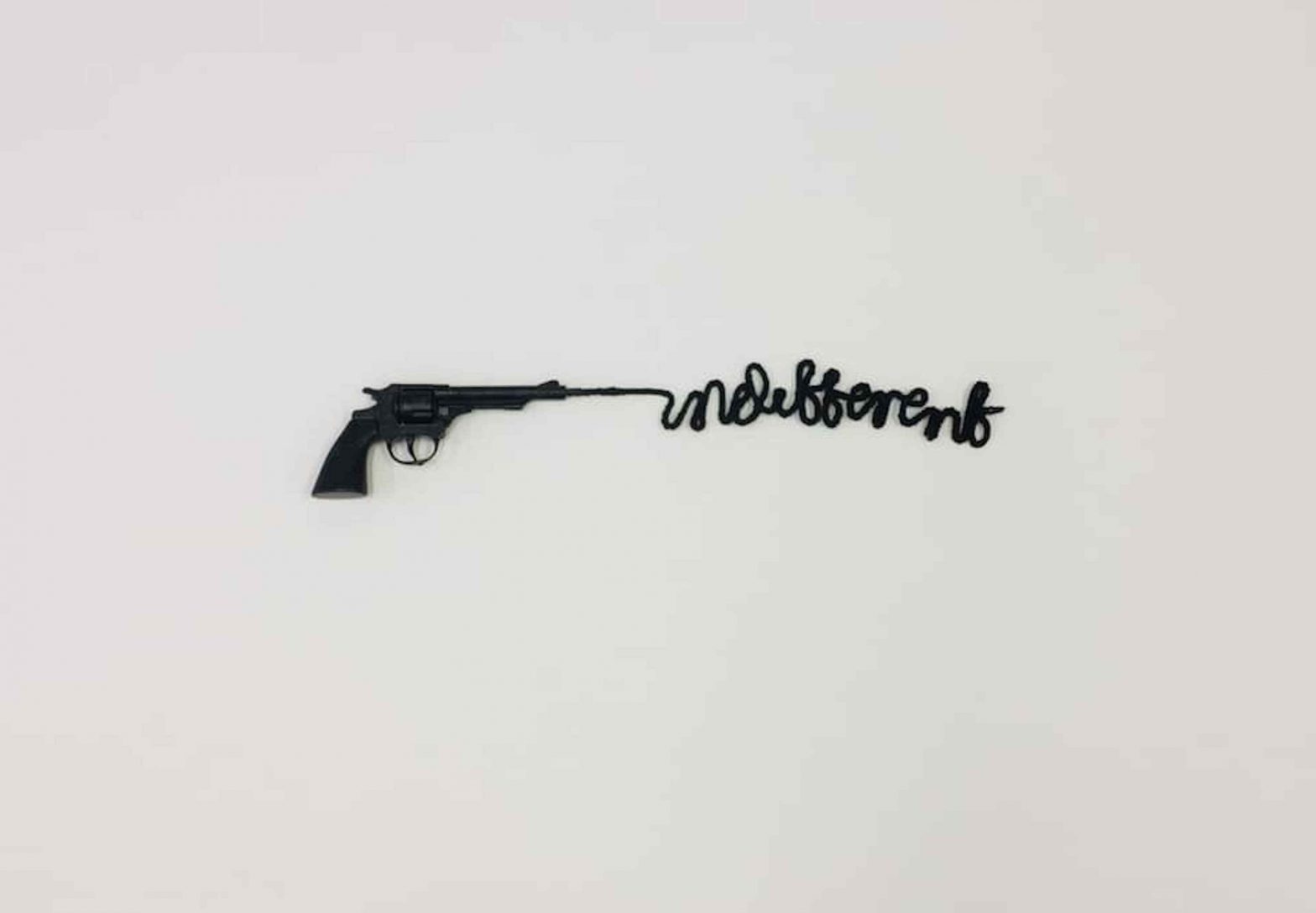 Image of a black gun shooting the word, in a single line of thick black paint 'indifferent'.