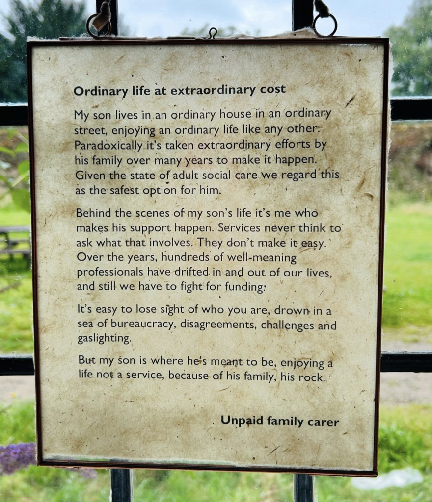 Image of a printed poem in a frame hanging in a window. Ordinary life at extraordinary cost My son lives in an ordinary house in an ordinary street, enjoying an ordinary life like any other. Paradoxically it’s taken extraordinary efforts by his family over many years to make it happen. Given the state of adult social care we regard this as the safest option for him. Behind the scenes of my son’s life it’s me who makes his support happen. Services never think to ask what that involves. They don’t make it easy. Over the years, hundreds of well-meaning professionals have drifted in and out of our lives, and still we have to fight for funding. It’s easy to lose sight of who you are, drown in a sea of bureaucracy, disagreements, challenges and gaslighting. But my son is where he’s meant to be, enjoying a life not a service, because of his family, his rock. Unpaid family carer